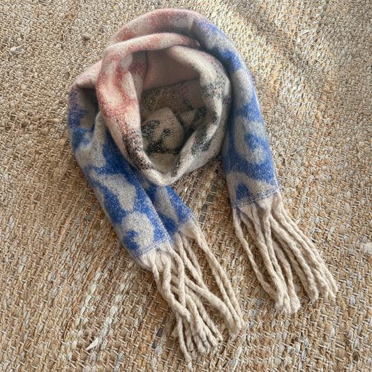 Plaid scarf with tassels on a textured surface
