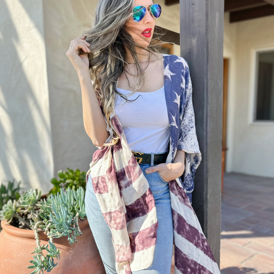 Woman wearing a colorful kimono with an American flag pattern, standing outdoors.