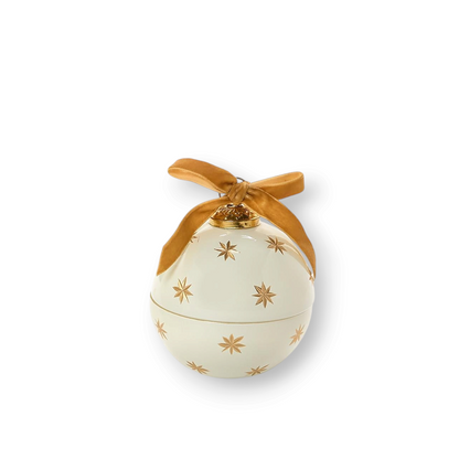 Mellow Monkey star-studded ornament candle in white glass with gold star patterns and a decorative gold ribbon bow