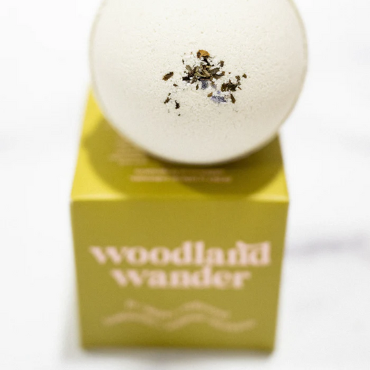 Bath bomb with decorative elements on a 'Woodland Wander' branded box against a white background