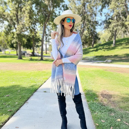 Woman wearing a colorful striped scarf with fringe in an outdoor setting
