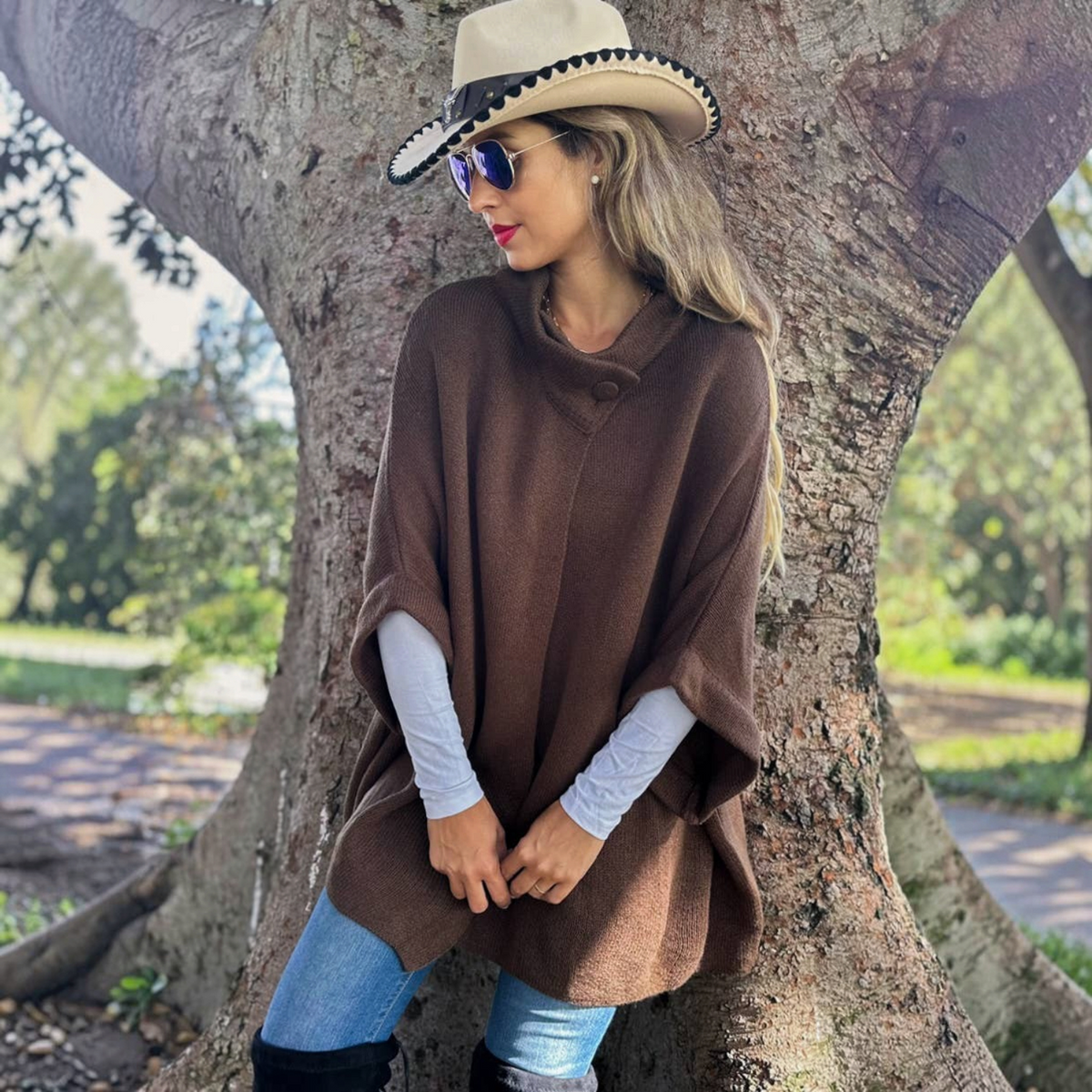 Mellow Monkey dark brown knit cape cardigan with a button neck detail worn over a white long sleeve top.