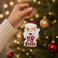 Mellow Monkey glass blown winking Santa ornament with Ho Fo Sho text and glitter details hanging on a Christmas tree.