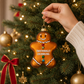 Mellow Monkey hand-blown glass gingerbread man ornament with Emotionally Crumbling text and glittery buttons.