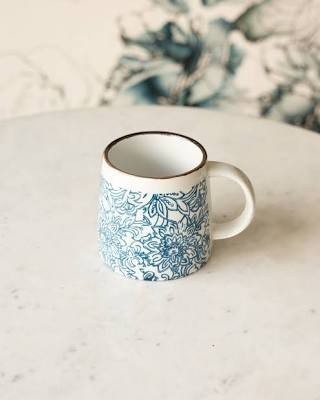 Mellow Monkey hand-stamped stoneware mug with blue floral design and gold rim detail. Microwave, dishwasher, and oven safe.