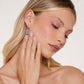 Mellow Monkey 18k gold plated earrings with glossy teal enamel gems and sterling silver posts, worn by a model.