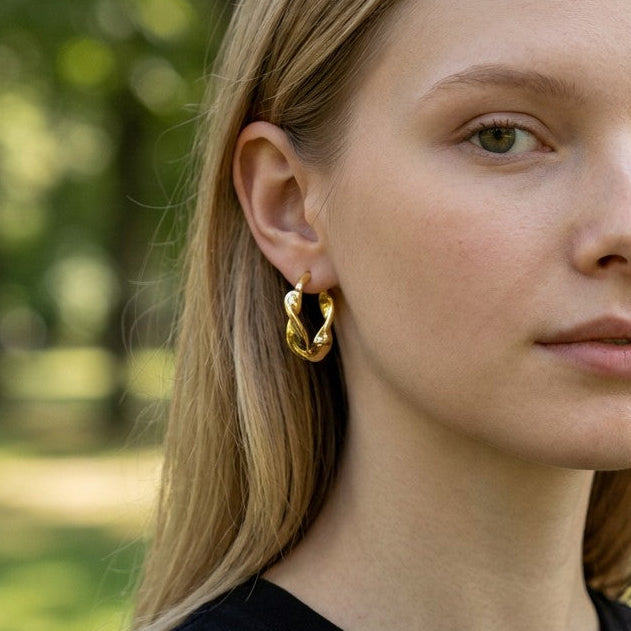 Mellow Monkey Spira Hoop Earrings in 18K Gold Vermeil, twisted design, worn by a model outdoors.