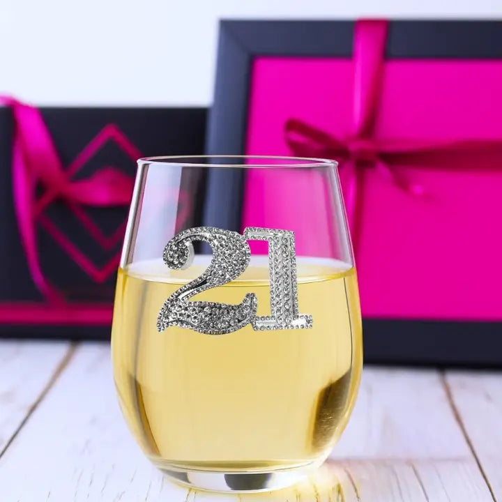 Mellow Monkey 21st birthday stemless wine glass featuring a decorative jeweled 21 emblem on a white wooden surface.