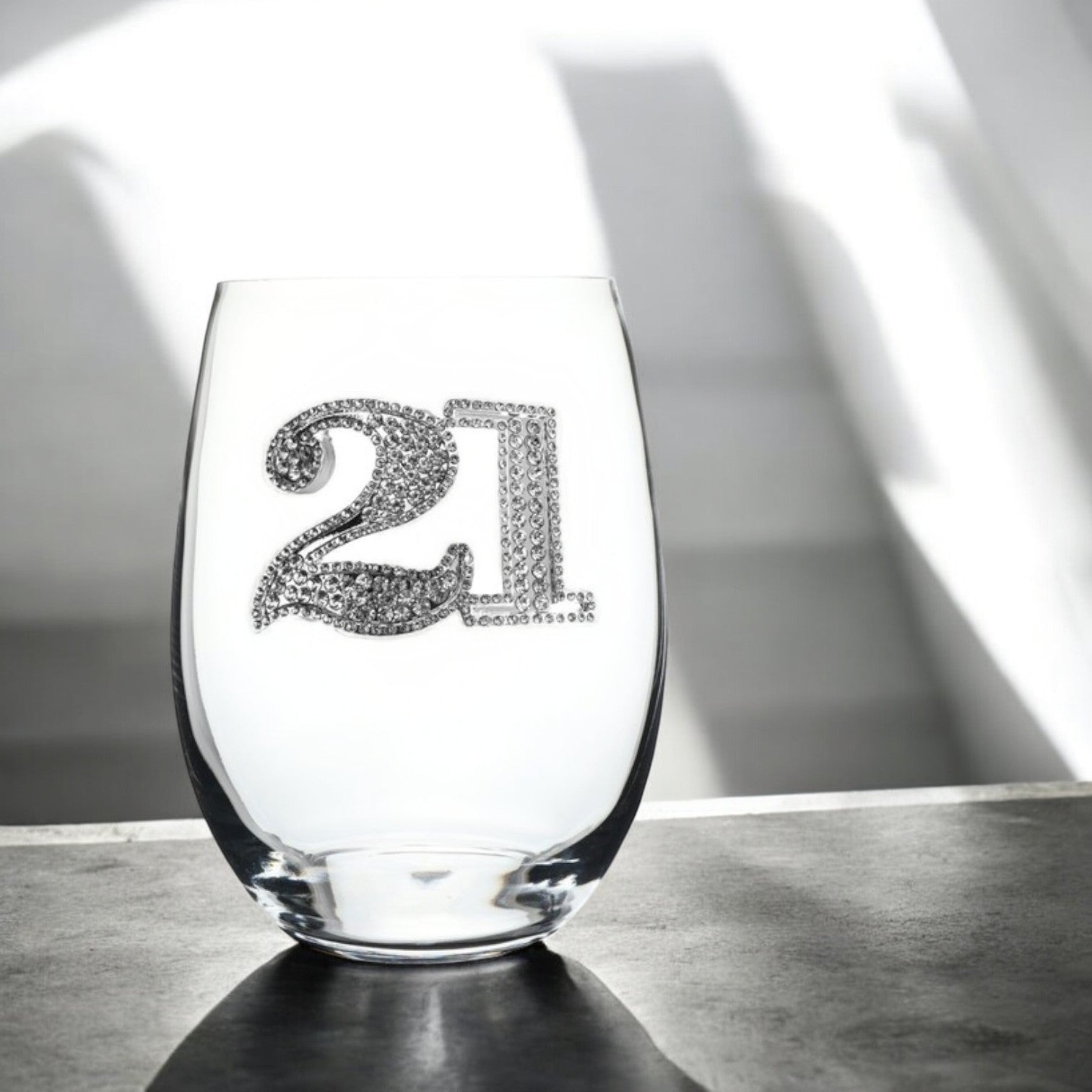 Mellow Monkey 21st birthday stemless wine glass decorated with sparkling silver rhinestones on a dark surface