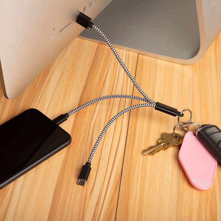 Mellow Monkey 3-in-1 charging keyring with black and white braided nylon cables connected to a phone and computer