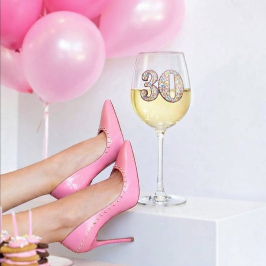 Mellow Monkey 30th birthday wine glass with jeweled number 30, displayed with pink heels and balloons