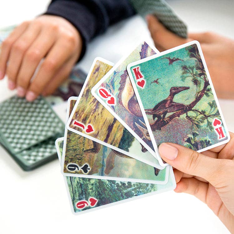 Mellow Monkey 3-D dinosaur playing cards with lenticular designs held in a hand during a poker game