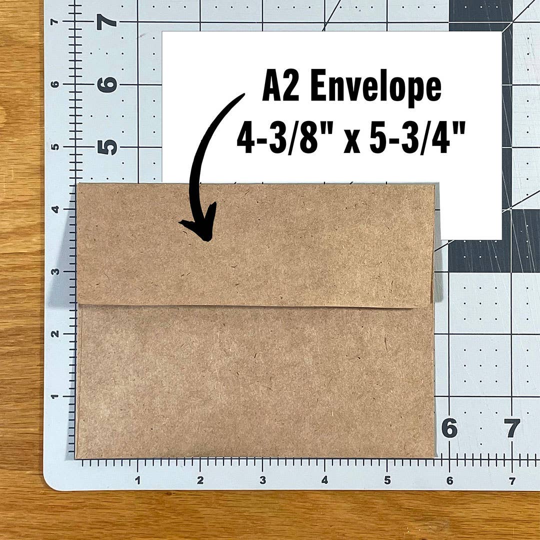 Mellow Monkey A2 kraft paper envelope for Christmas cards on a cutting mat