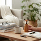 Mellow Monkey acacia wood fox-shaped salt and pepper mill with faux leather ears on a wooden table with a coffee mug