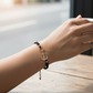 Mellow Monkey Kitt adjustable black braided bracelet featuring a gold-tone anchor charm with sparkling crystals