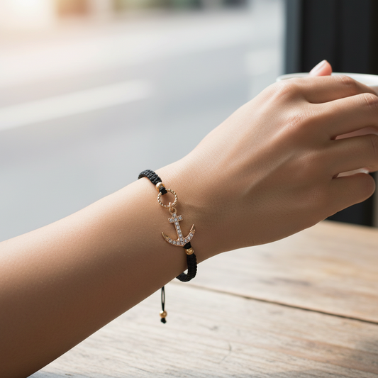 Mellow Monkey Kitt adjustable black braided bracelet featuring a gold-tone anchor charm with sparkling crystals