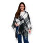 Woman wearing a Mellow Monkey Alora open front black and white plaid wrap with fringe detail over a white top