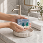 Mellow Monkey Alpine Frost handmade bar soap with blue and white marbled design being rinsed under bathroom faucet