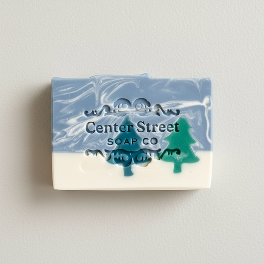 Mellow Monkey Alpine Frost handmade bar soap with blue and white marbled design and pine tree cutouts.