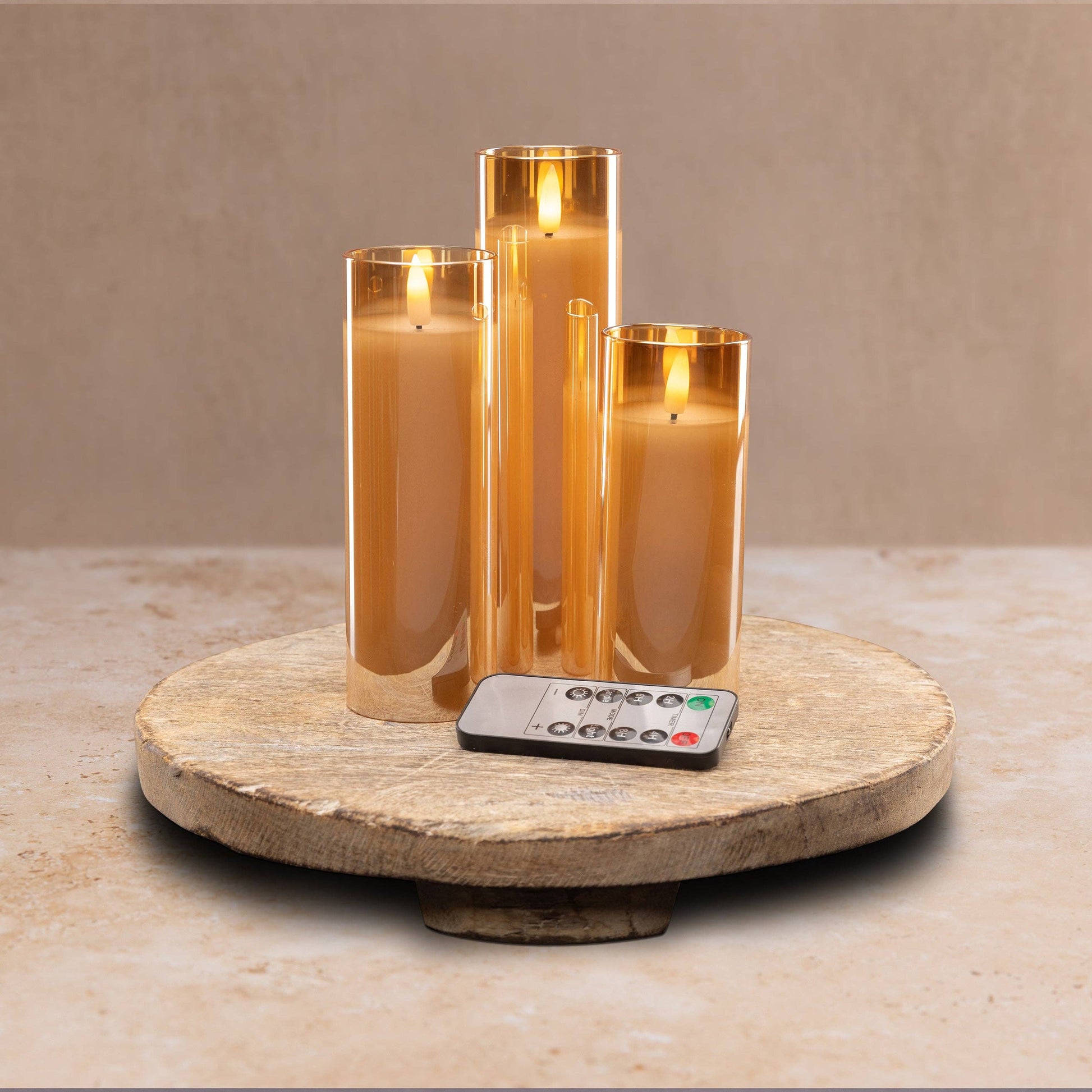 Mellow Monkey set of three amber glass LED flameless pillar candles with remote control on a rustic wooden tray