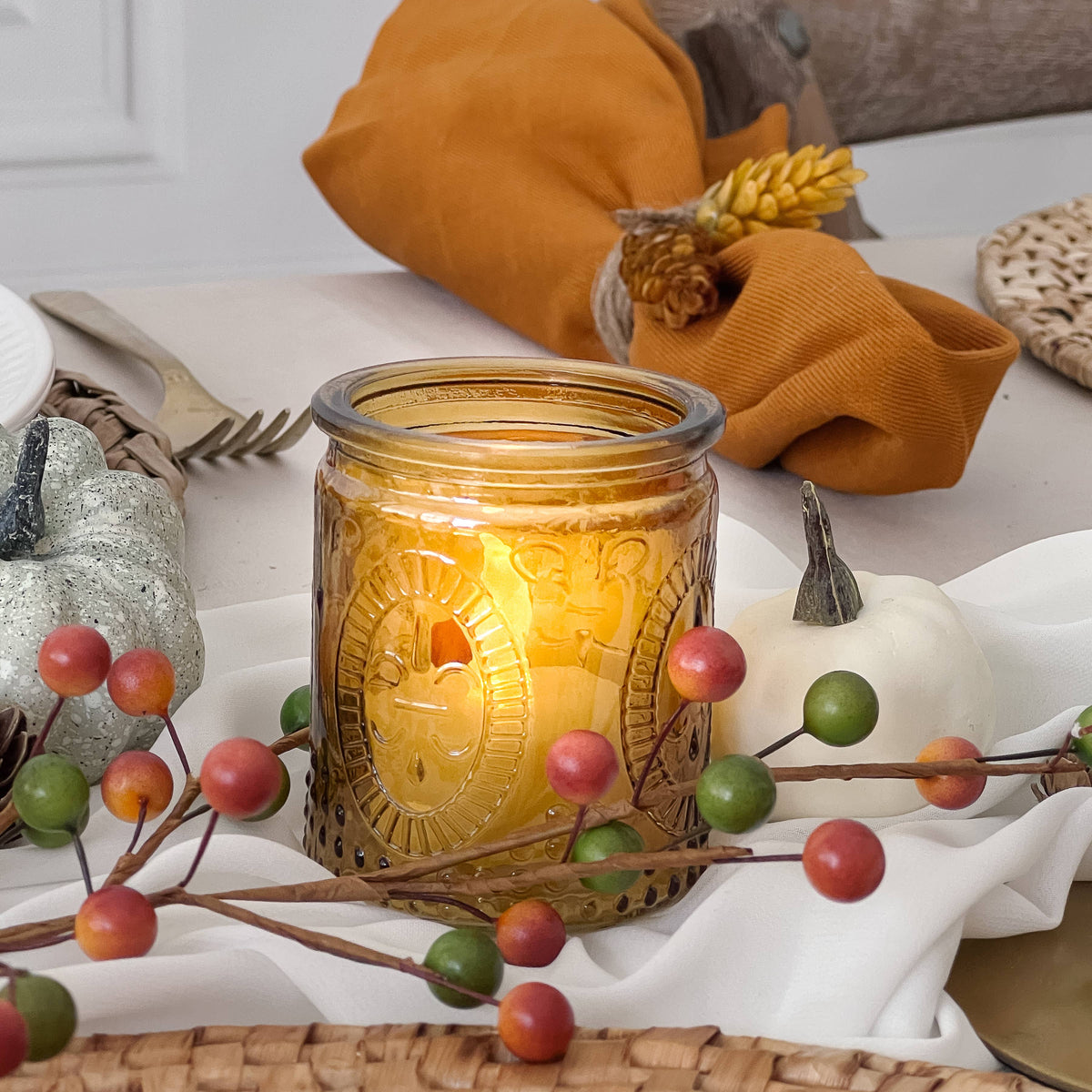 Mellow Monkey vintage amber glass tea light holder with embossed pattern glowing on a festive autumn table setting