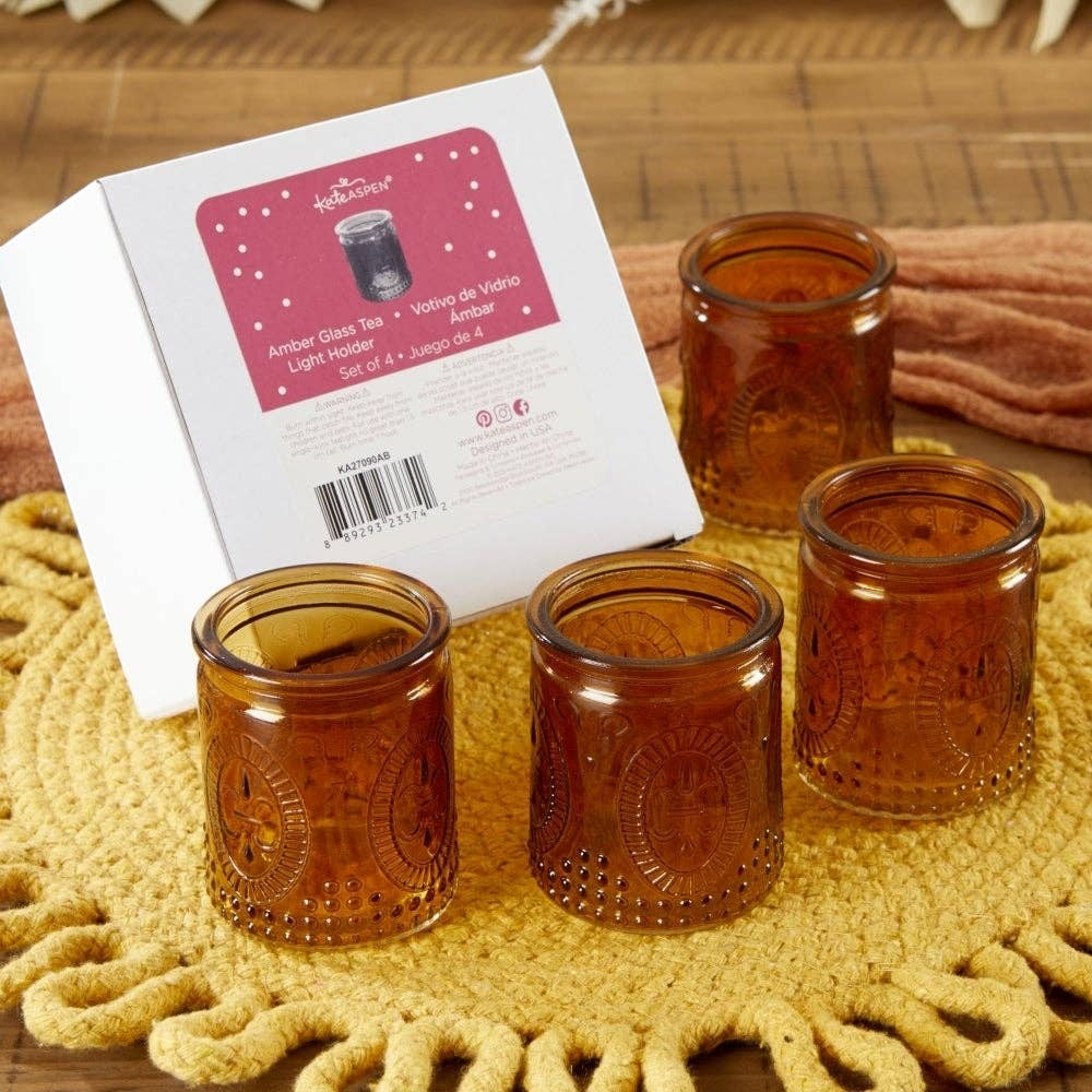 Mellow Monkey set of four vintage amber glass tea light holders with embossed floral patterns on a yellow placemat.