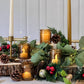 Mellow Monkey set of 4 vintage amber glass tea light holders styled with eucalyptus, pinecones, and holiday decor.