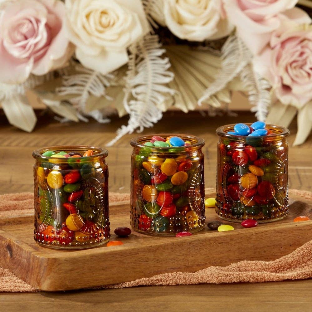 Mellow Monkey vintage amber glass tea light holders filled with colorful candies on a wooden tray with floral decor