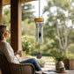 Mellow Monkey amethyst mini healing wind chime with aluminum tubes hanging on a serene porch with a woman relaxing.
