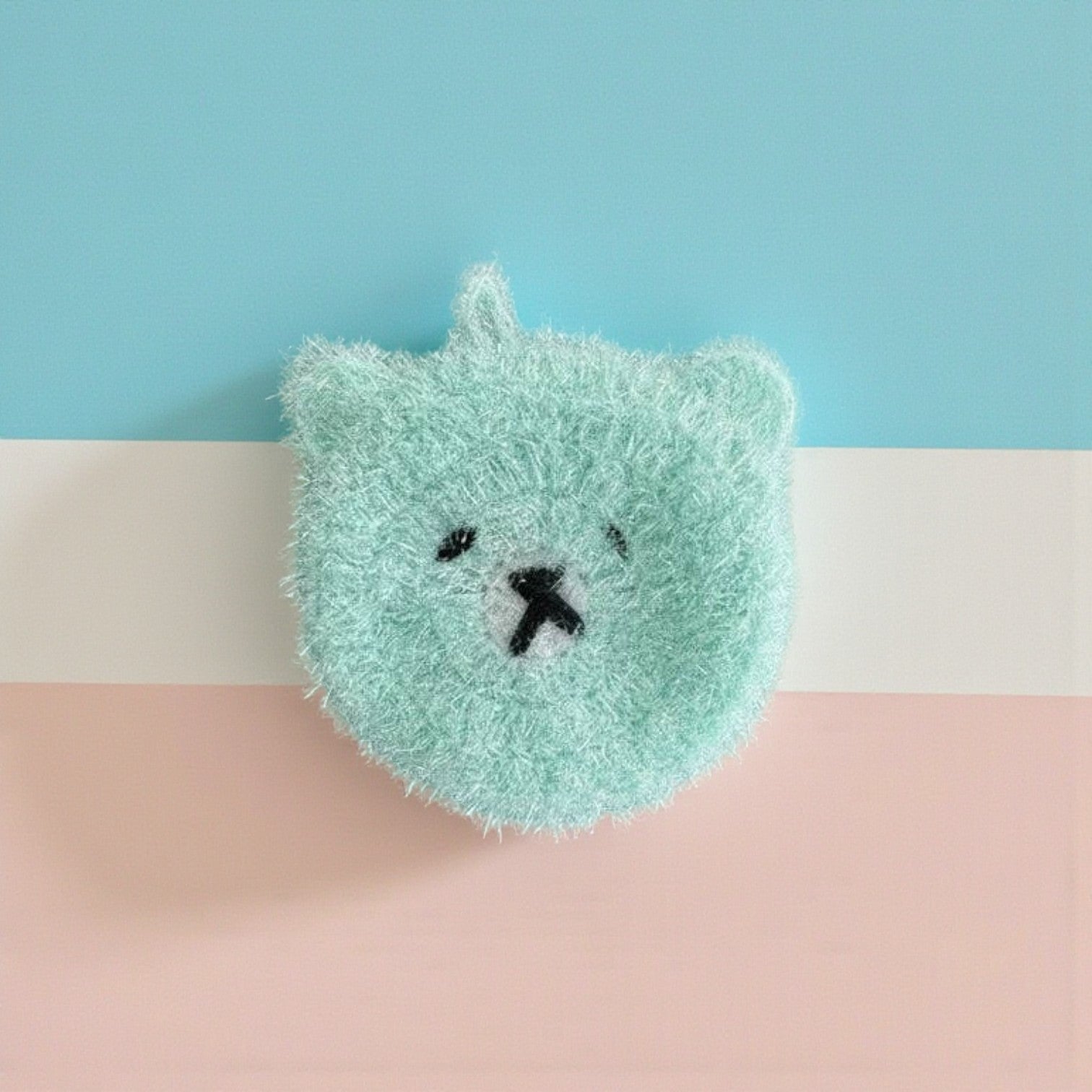 Mellow Monkey Good News Bears scrubby sponge in soft aqua. Features a cute bear face with embroidered eyes and nose. Dual-sided for versatile cleaning.