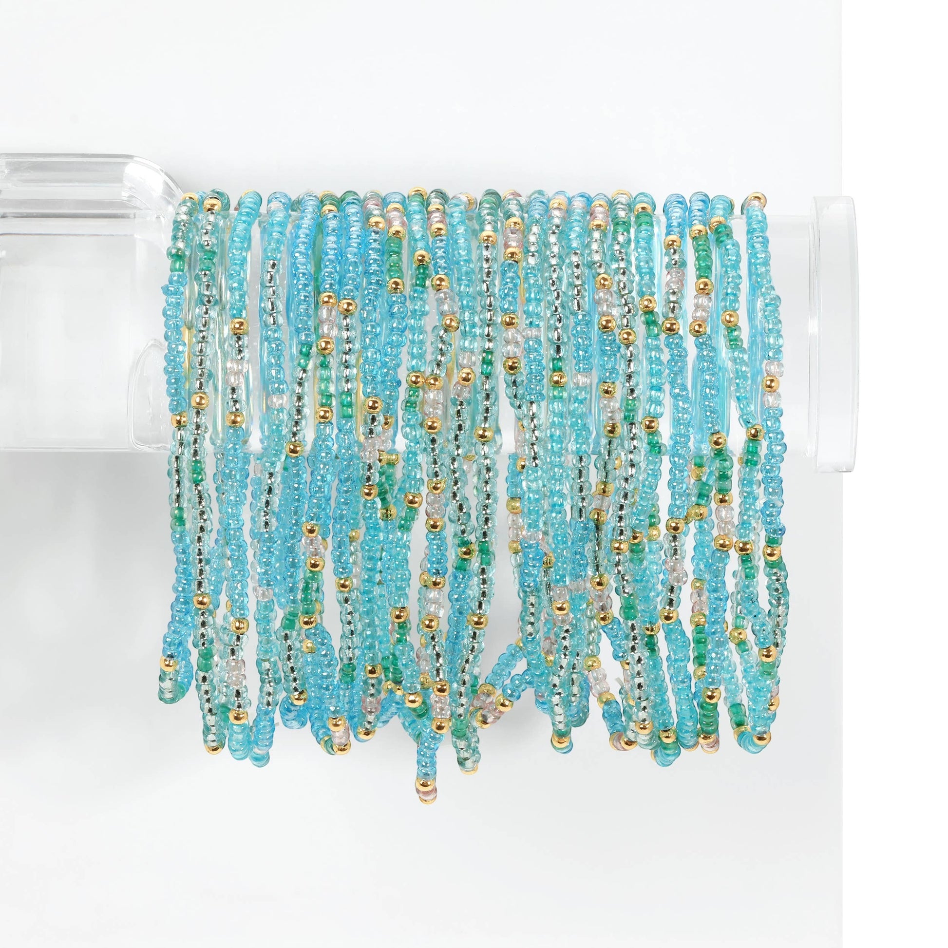 Mellow Monkey aqua seaglass stretch seed bead bracelets with 18k gold plated accents on a display stand.