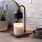 Mellow Monkey black and wood arched candle warmer lamp with a lit jar candle on a kitchen counter.