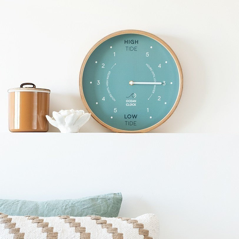 Mellow Monkey Arctic Turquoise Wooden Tide Clock with beech frame, white hands, and mineral glass face. Displays high and low tide times.