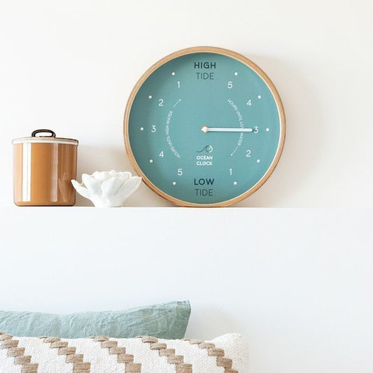 Mellow Monkey Arctic Turquoise Wooden Tide Clock with beech frame, white hands, and mineral glass face. Displays high and low tide times.