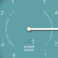 Mellow Monkey Arctic Turquoise Wooden Tide Clock with white hands and face, showing hours until high or low water.