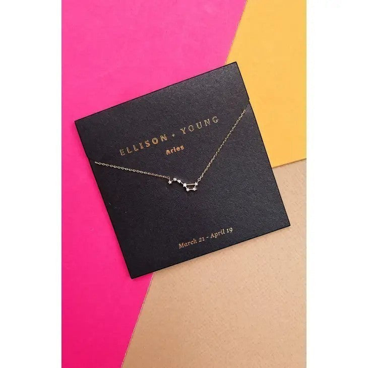 Mellow Monkey gold Aries zodiac constellation necklace with cubic zirconia on a black card with astrological dates.