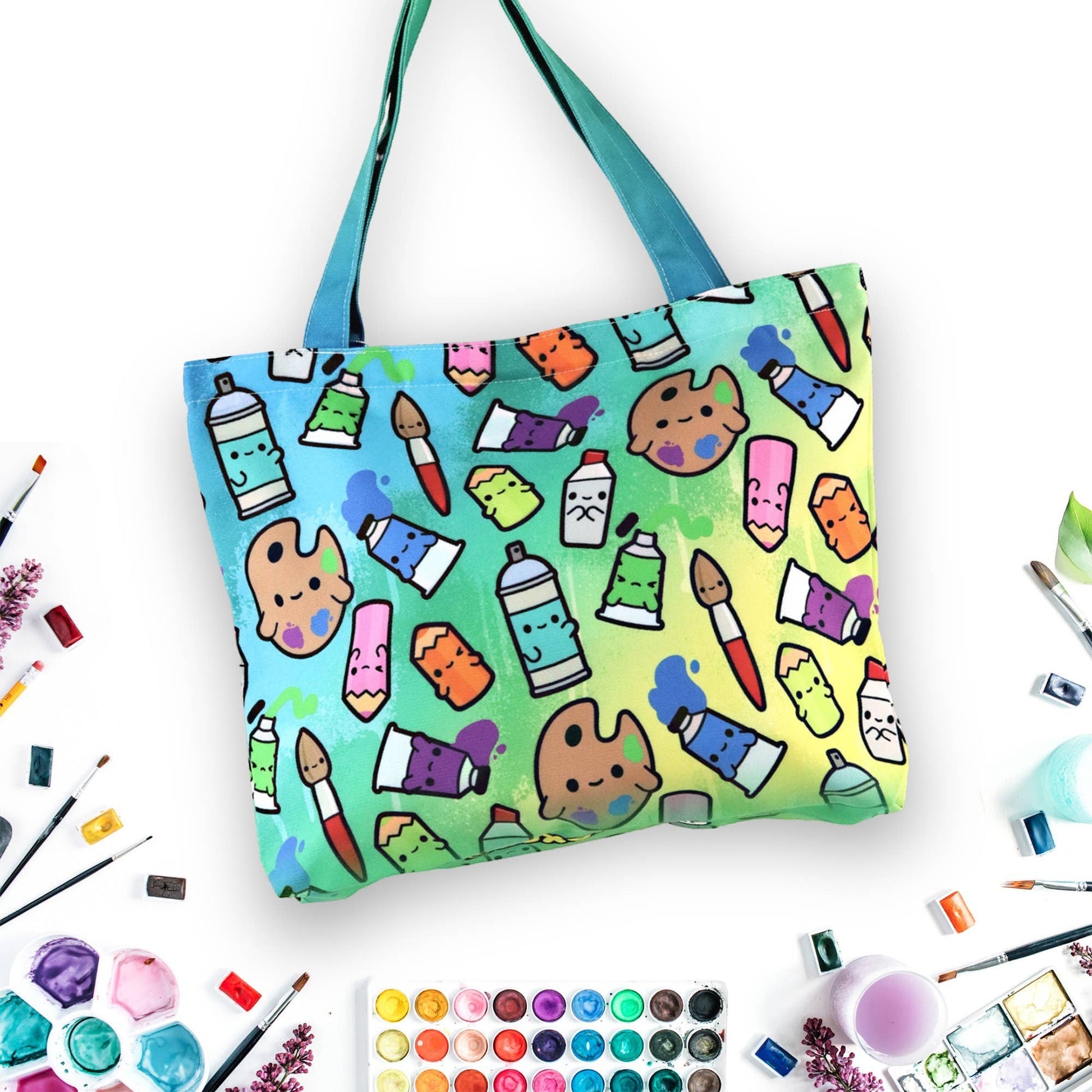 Mellow Monkey art supplies tote bag with a colorful gradient background and a pattern of cute art supplies like paint tubes, palettes, and spray cans.