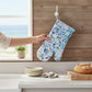 Mellow Monkey Atlantic Reef cotton oven mitt featuring blue and white abstract oyster shell art in a kitchen setting
