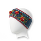 Mellow Monkey Aubrey denim blue hand-knit wool headband featuring colorful floral embroidery and striped patterns.