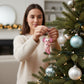 Mellow Monkey pink blown glass axolotl ornament holding a red and white candy cane, Christmas tree decor