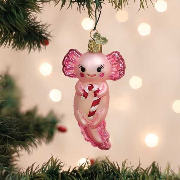 Mellow Monkey pink blown glass axolotl ornament holding a red and white candy cane, festive holiday decor