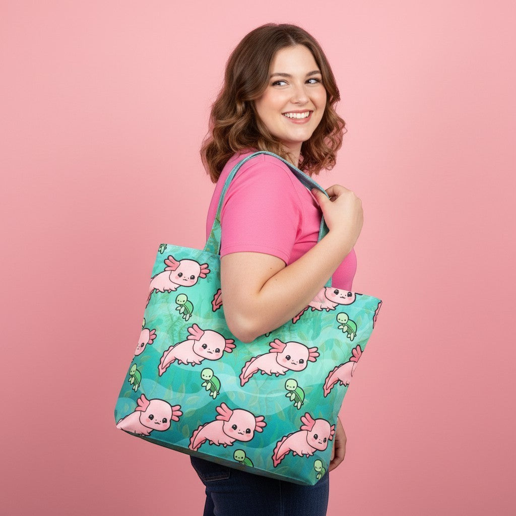 Mellow Monkey pink axolotl print tote bag with teal background and interior zippered pocket, held by a woman.
