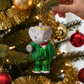 Mellow Monkey Babar the Elephant glass Christmas ornament with a green glitter suit and gold crown on a tree