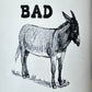 Mellow Monkey black and white ceramic 11-oz mug with "BAD" text and a donkey illustration. Microwave and dishwasher safe.