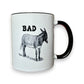 Mellow Monkey white ceramic mug with black trim, featuring the word BAD and a donkey illustration. 11-oz.