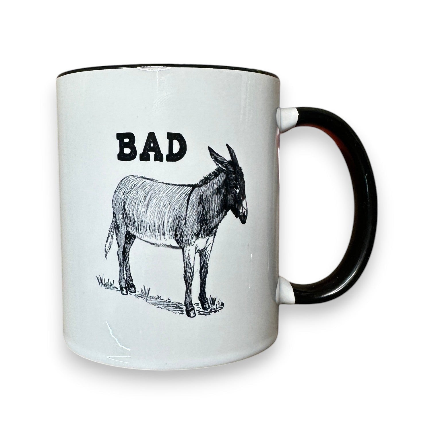 Mellow Monkey white ceramic mug with black trim, featuring the word BAD and a donkey illustration. 11-oz.