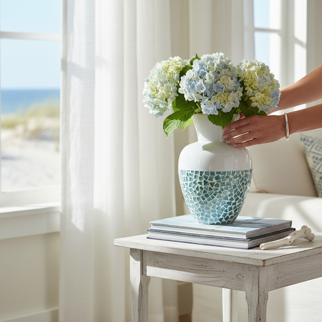 Mellow Monkey 14-inch bamboo and capiz shell vase with blue mosaic and white top, holding hydrangeas on a side table.