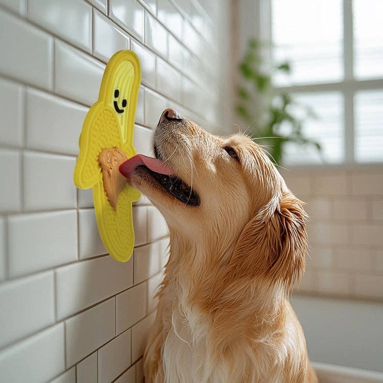 Mellow Monkey yellow banana-shaped silicone lick mat with peanut butter, for dogs.