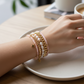 Mellow Monkey bracelet stack featuring freshwater baroque pearls, pink crystals, and 14K gold-plated star charms.