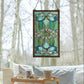 Mellow Monkey Baroque stained glass window panel with blue and green ribbons, cabochons, and metal frame hanging.